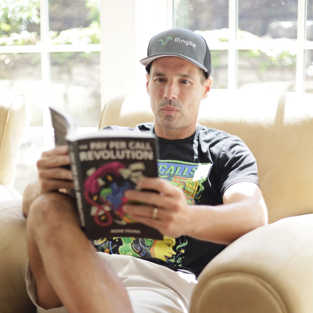 Ringba User Stories - Matt Zivkovic reading The Pay Per Call Revolution in a chair